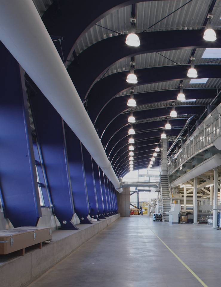 Een moderne interieur met hoge, gewelfde plafonds, blauwe muren en gelijkmatig verdeelde plafondlampen.