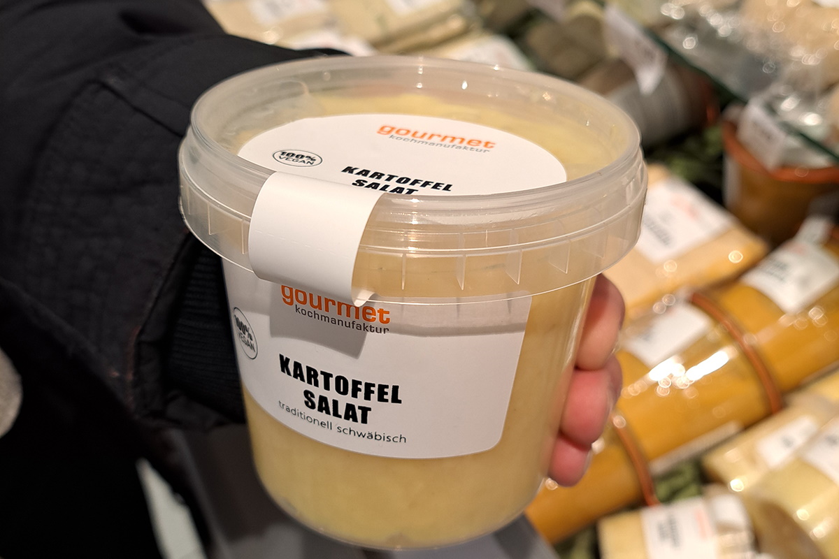 Translation: "Oplossingen Voedsel: Twee-in-één product- en sluitetiket, speciale vorm voor het verbinden van lichaam en deksel, aardappelsalade in kunststof beker.