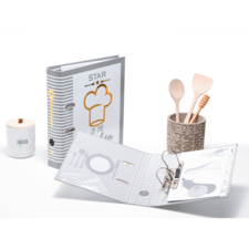 Kochbuch mit dem Titel "Star of the Kitchen", Holzlöffel, Behälter mit Küchenutensilien und Zuckergefäß.