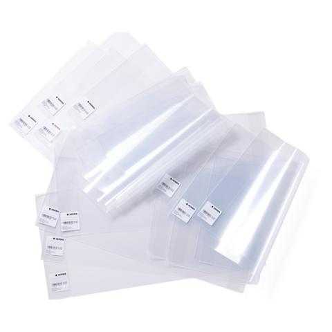 Eine Ansammlung von transparenten Kunststoffhüllen in verschiedenen Größen, einige mit Etiketten, die zur Aufbewahrung von Dokumenten verwendet werden.