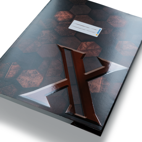 Ein schwarzes Notizbuch mit einem glänzenden, stilisierten "X" auf der Vorderseite, das auf einem hexagonalen Muster liegt.