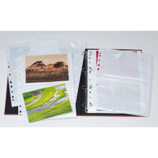 Ein Fotoalbum mit leeren Hüllen und zwei eingelegten Bildern, eines zeigt eine Landschaft und das andere Reisfelder.