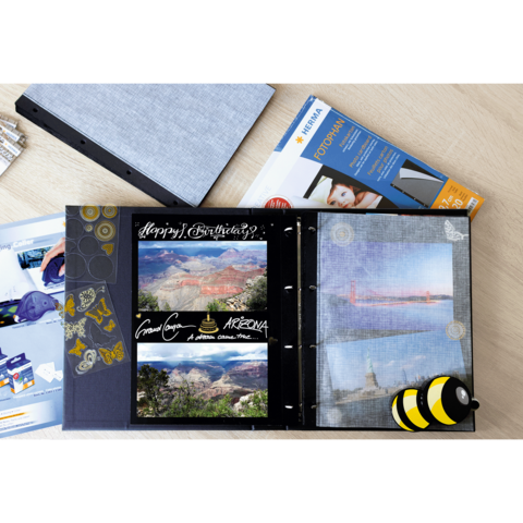 Ein Fotoalbum mit Bildern von Landschaften, darunter der Grand Canyon, und einer Geburtstagsnachricht. Daneben liegen Fotomaterialien.