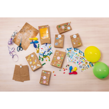 Bastelmaterialien auf einem Tisch, einschließlich Papiertüten, Aufkleber, Scheren, Ballons und bunten Perlen.