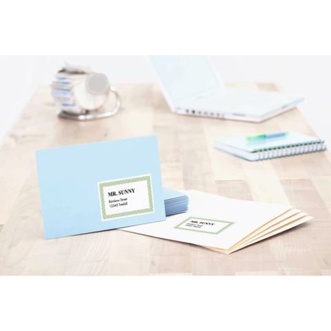 Blaue Karte mit dem Namen "MR. SUNNY" und der Aufschrift "Tischkarten" auf einem Holztisch, umgeben von weiteren Briefkarten und Büromaterial.