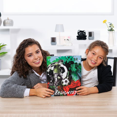 Twee meisjes houden een voetbalrapport met een grafiek en de score 3:2 vast. Ze zitten aan een tafel in een lichte kamer.