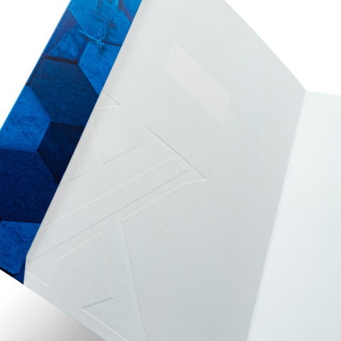 Ein offenes Notizbuch mit einem blauen, geometrischen Cover und leeren Seiten im Inneren.