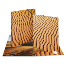 Sanddünen mit markanten Wellenmustern, die die Textur und Farbe des Sandes hervorheben.